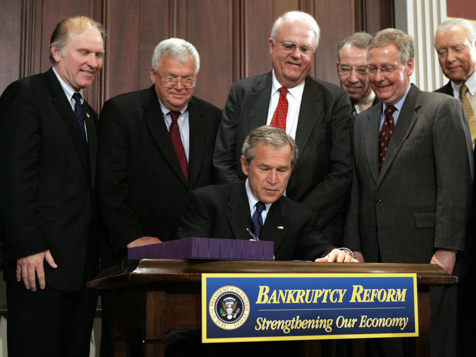 WASHINGTON, UNITED STATES:  US President George W. Bush(C) signs S. 256, the Bankruptcy Abuse Prevention and Consumer Protection Act of 2005 in the Old Executive Office Building 20 April, 2005 in Washington, DC.  Retailers and landlords are supporting the new law which is expected to improve their legal positions against defaulting consumers and retail tenants.  AFP PHOTO/Brendan SMIALOWSKI  (Photo credit should read BRENDAN SMIALOWSKI/AFP via Getty Images)