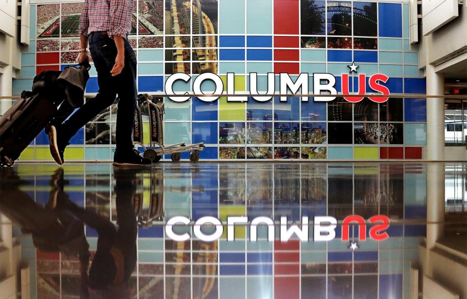 A traveler walks through the John Glenn Columbus International Airport terminal.