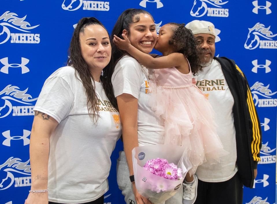 Mountain House girls basketball player Cayla Harang, center, poses for a picture with her mother Cassie, left,  her 3-year-old daughter Royalty and her father Ronald after she a letter if intent to play for the University of La Verne during a ceremony at the high school in Tracy on Wednesday, Apr. 12, 2023.