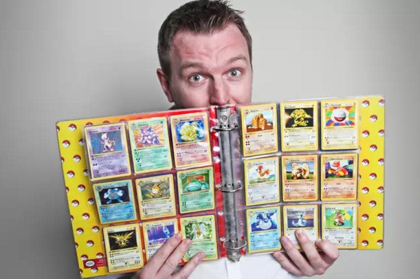 Nigel Brookes posa con su colección de la niñez de cartas Pokémon que pondrá en breve a la venta. Fuente de la imagen: Tarreo.