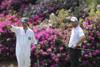 Caddy Adam Hayes, left, gestures beside Jon Rahm, right, as Rahm prepares to putt on the 13th hole during a practice round for the Masters golf tournament in Augusta, Ga., Wednesday, April 7, 2021. (Curtis Compton/Atlanta Journal-Constitution via AP)