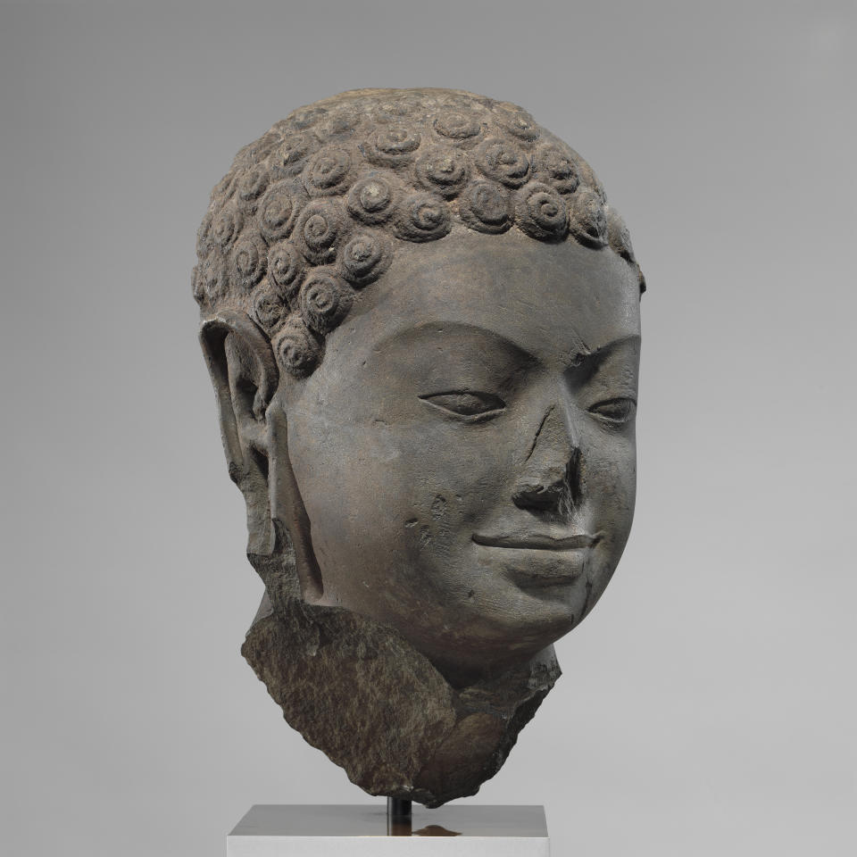 This December 2005 photo shows a 7th century sculpture titled "Head of Buddha" at the Metropolitan Museum of Art in New York. The sculpture is one of 16 pieces of artwork that the museum said it will return to Cambodia and Thailand that federal prosecutors say were tied to an art dealer and collector accused of running a huge antiquities trafficking network out of Southeast Asia. (Metropolitan Museum of Art via AP)