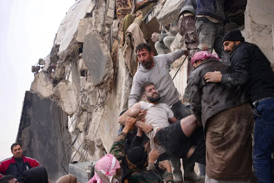 Residents retrieve an injured man from the rubble of a collapsed building following an earthquake in the town of Jandaris, in the countryside of Syria's northwestern city of Afrin (AFP via Getty Images)
