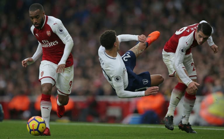 Tottenham Hotspur's Dele Alli (centre) takes a tumble during the Premier League clash against Arsenal at the Emirates Stadium in London, on November 18, 2017