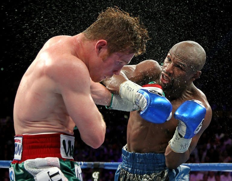 Floyd Mayweather (R) throws a right at Saul Alvarez during their WBC/WBA super welterweight fight at the MGM Grand Garden Arena in Las Vegas on September 14, 2013