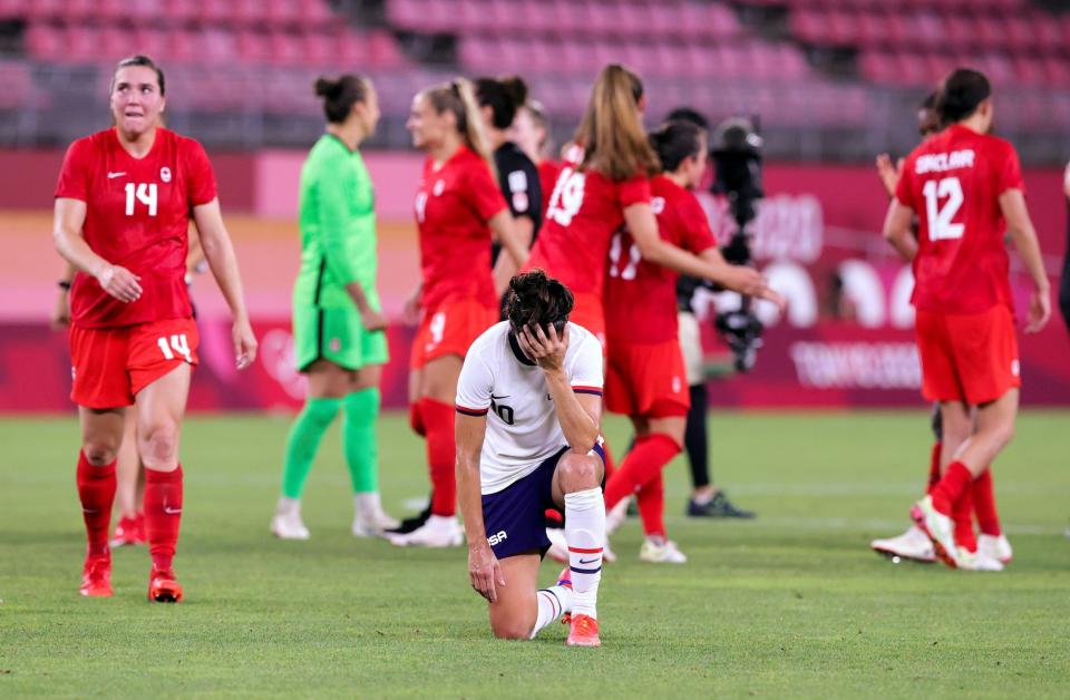 Carli Lloyd kneels in defeat after the USWNT's Olympics loss to Canada.