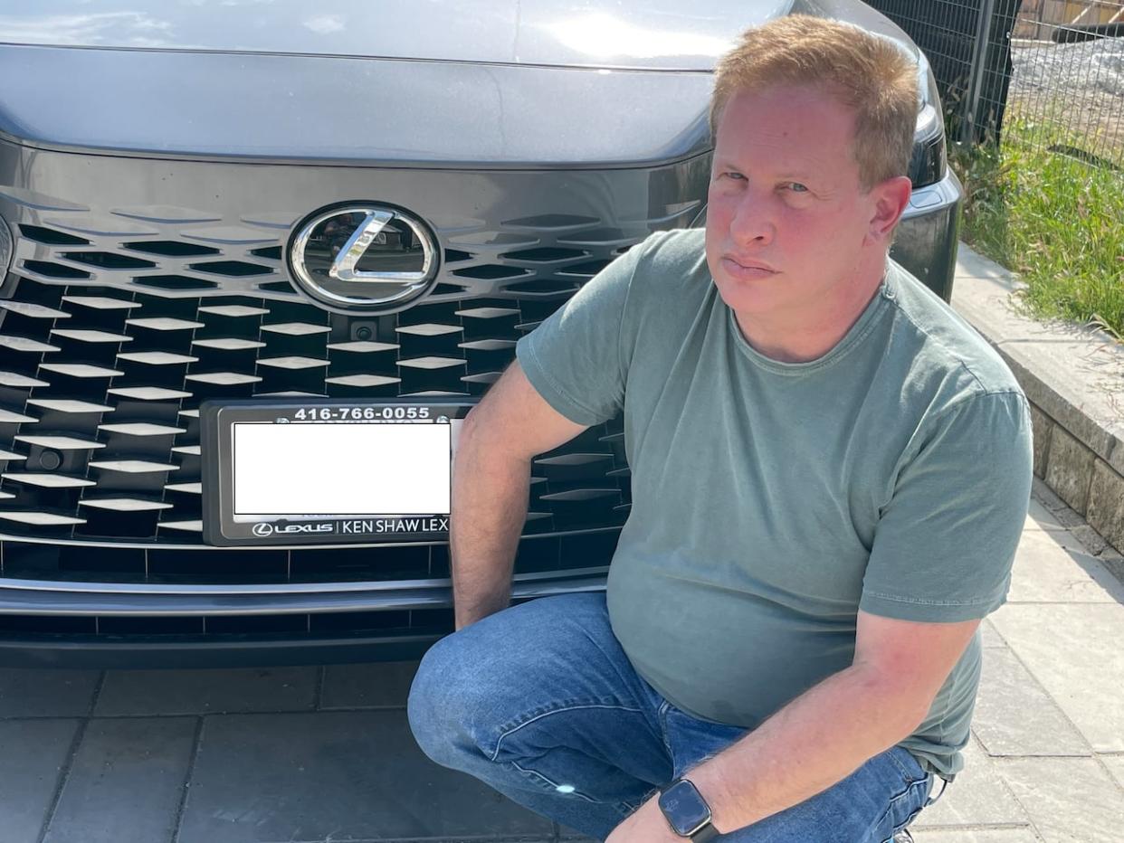 Mitchell Levine with the Lexus he bought in July. Two months after the dealership told him he had to remove his after-market safety device, the vehicle in this photo was stolen. (Sue Goodspeed/CBC  - image credit)