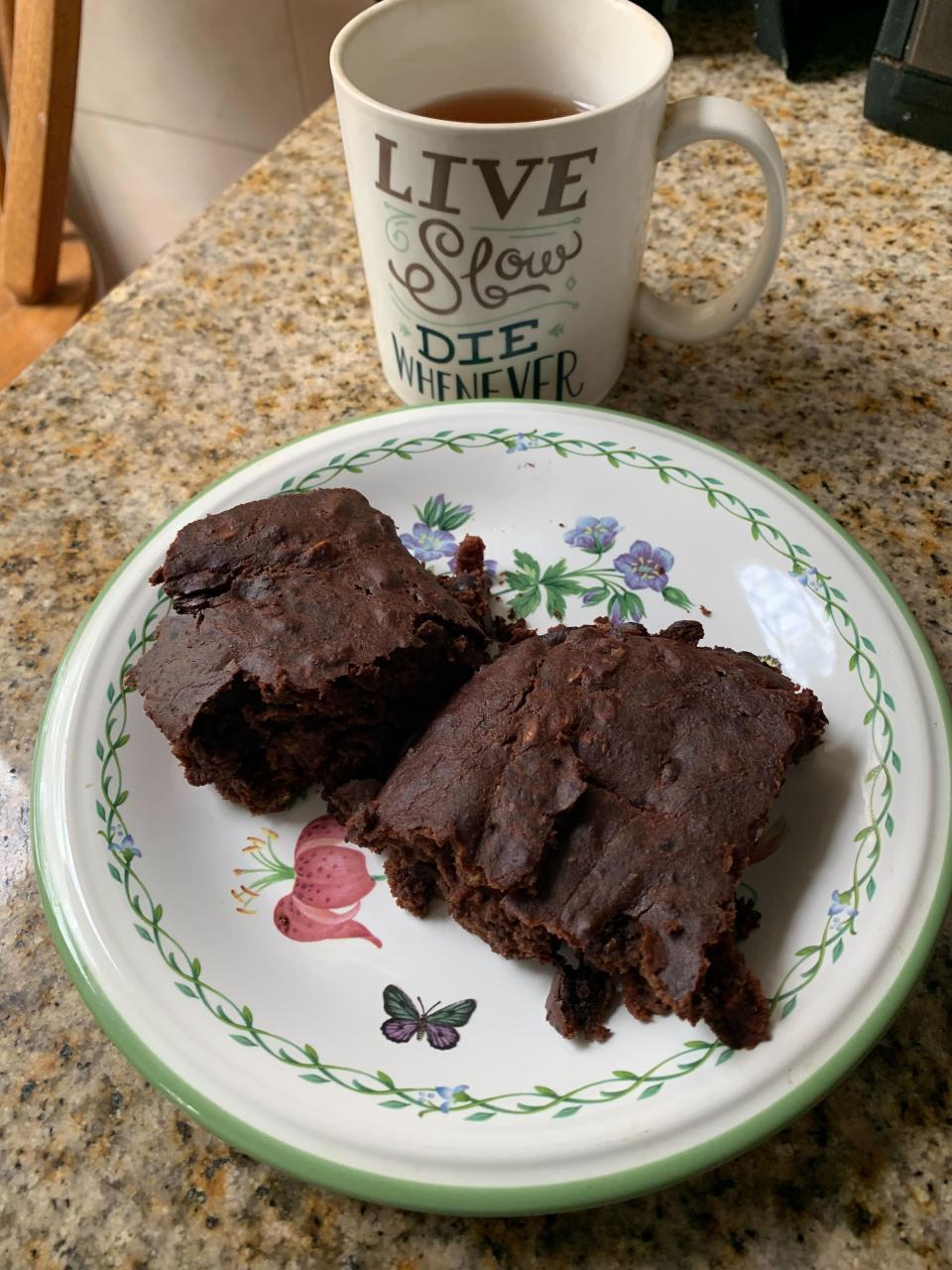 a plate of brownies next to a mug of tea that reads "live slow, die whenever"