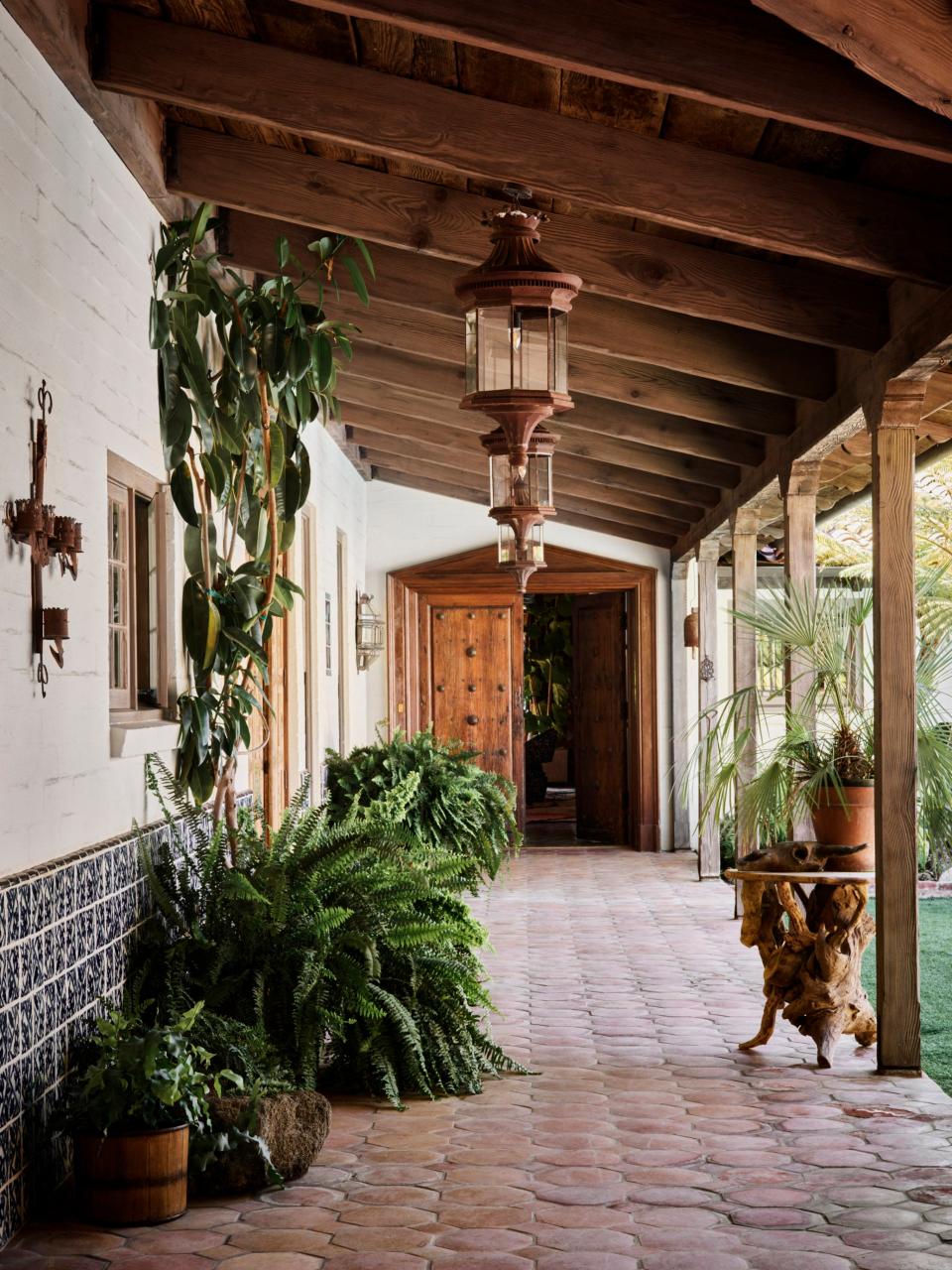 Saltillo tile floors extend from the exterior of the home to the interior. The pool is situated in the courtyard to the right.