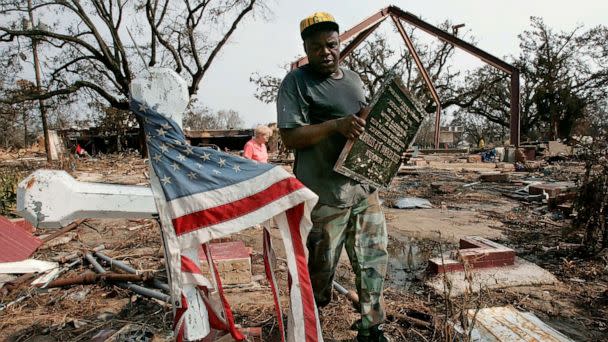 PHOTO: Thomas Walker, the sexton of the Episcopal Church of the Redeemer carries a bronze plaque from the church which was destroyed by Hurrican Katrina, Sept. 1, 2005 in Biloxi, Miss. (Win Mcnamee/Getty Images, FILE)