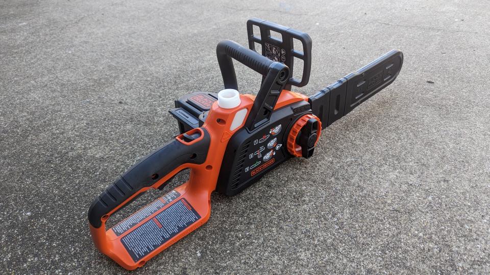 Image showing the BLACK + DECKER 40V MAX 12-inch Cordless Chainsaw with chain oil cap open and blade cover on