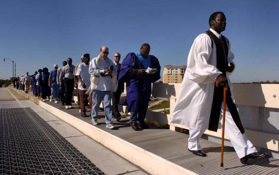 On Dec. 3, 2005, Union Missionary Baptist Church Pastor James Mitchell, right, leads his congregation from City Hall to their restored church in Venice. City leaders joined in the march to recognize the two year struggle to rebuild the church after a broken city sewer pipe flooded the building.