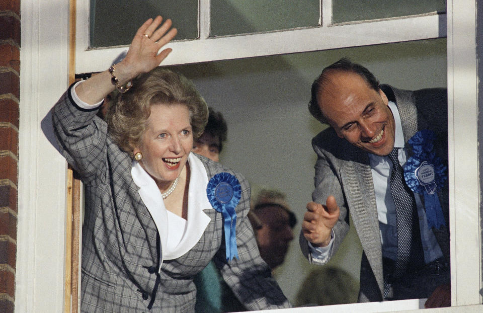 FILE - British Prime Minister Margaret Thatcher waves to supporters from Conservative Party headquarters in London, June 12, 1987, after claiming victory in Britain's general election. Two people are running to be Britain’s next prime minister, but a third presence looms over the contest: Margaret Thatcher. Almost a decade after her death, the late former prime minister casts a powerful spell over Britain's Conservative Party. In the race to replace Boris Johnson as Conservative leader and prime minister, both Foreign Secretary Liz Truss and former Treasury chief Rishi Sunak claim to embody the values of Thatcher. (AP Photo/File)