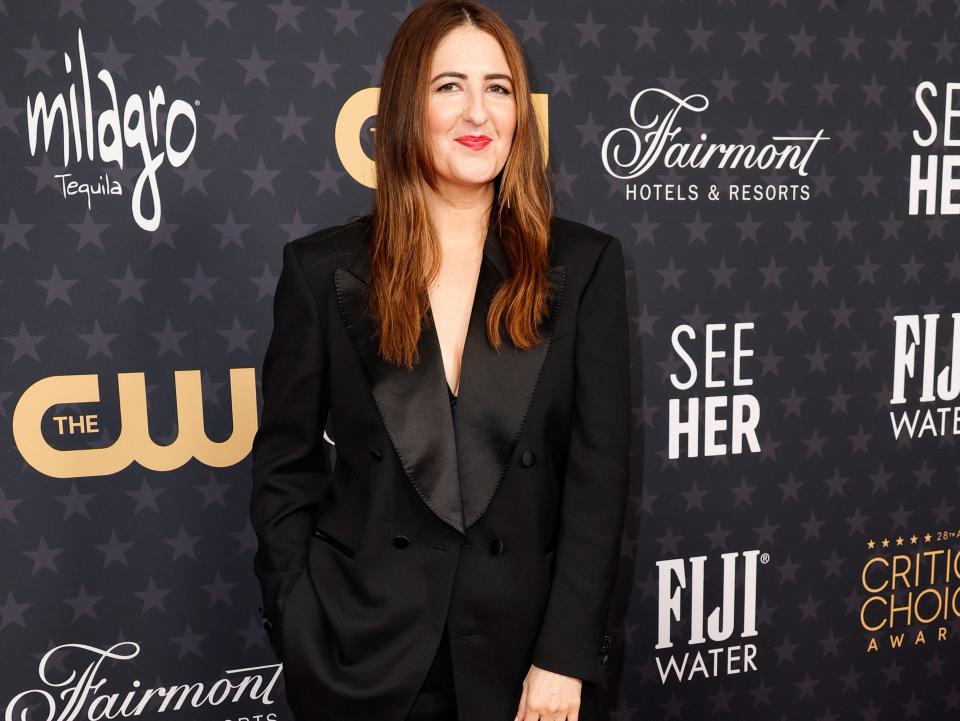 D'Arcy Carden wearing a black suit.