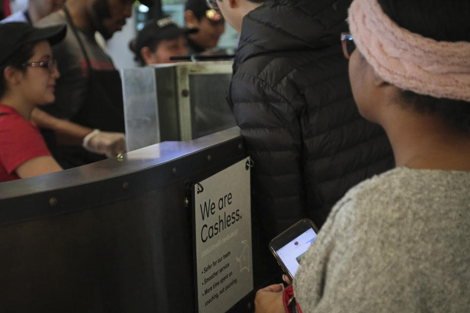 A restaurant sign alert customers that it's now "cashless," Thursday Jan. 23, 2020, in New York. Lawmakers in New York City were voting Thursday on a measure to require stores and restaurants to accept cash. Critics of the cash-free business model say it discriminates against people who don't have bank accounts or who prefer to use cash. (AP Photo/Bebeto Matthews)