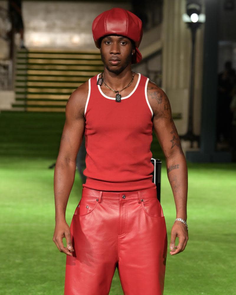 A model wears a red design on the Mains catwalk