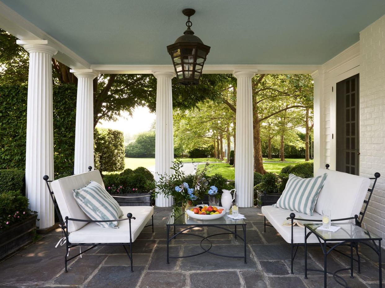 a patio with white chairs and a table with a white table and a white table with a white