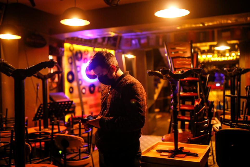 <p>A man waits outside a closed restaurant</p> (AP)