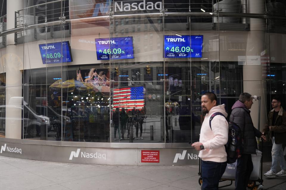 Pedestrians walk past the Nasdaq building Tuesday, March 26, 2024, in New York. Trump Media, which runs the social media platform Truth Social, now takes Digital World's place on the Nasdaq stock exchange. (AP Photo/Frank Franklin II)