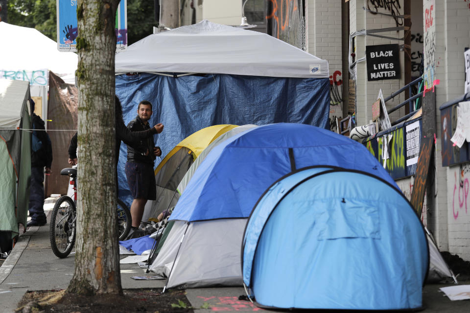 Tents line a sidewalk adjacent to a closed Seattle police precinct Sunday morning, June 28, 2020, in Seattle, where several streets are blocked off in what has been named the Capitol Hill Occupied Protest zone. Seattle Mayor Jenny Durkan met with demonstrators Friday after some lay in the street or sat on barricades to thwart the city's effort to dismantle the protest zone that has drawn scorn from President Donald Trump and a lawsuit from nearby businesses. (AP Photo/Elaine Thompson)