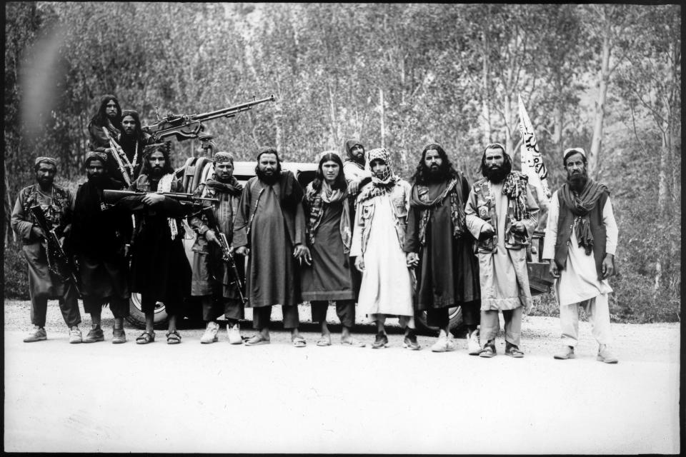 Taliban fighters pose for a portrait at a makeshift checkpoint in Wardak province, Afghanistan, Monday, June 19, 2023. (AP Photo/Rodrigo Abd)