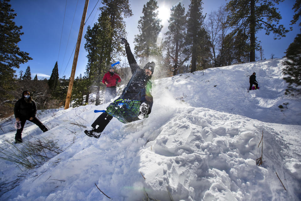 Mario Barba, of Inglewood, Calif., soars off a makeshift snow jump following recent snowfall in the San Gabriel Mountains, near Wrightwood, on Jan. 27, 2021. / Credit: Allen J. Schaben / Los Angeles Times via Getty Images