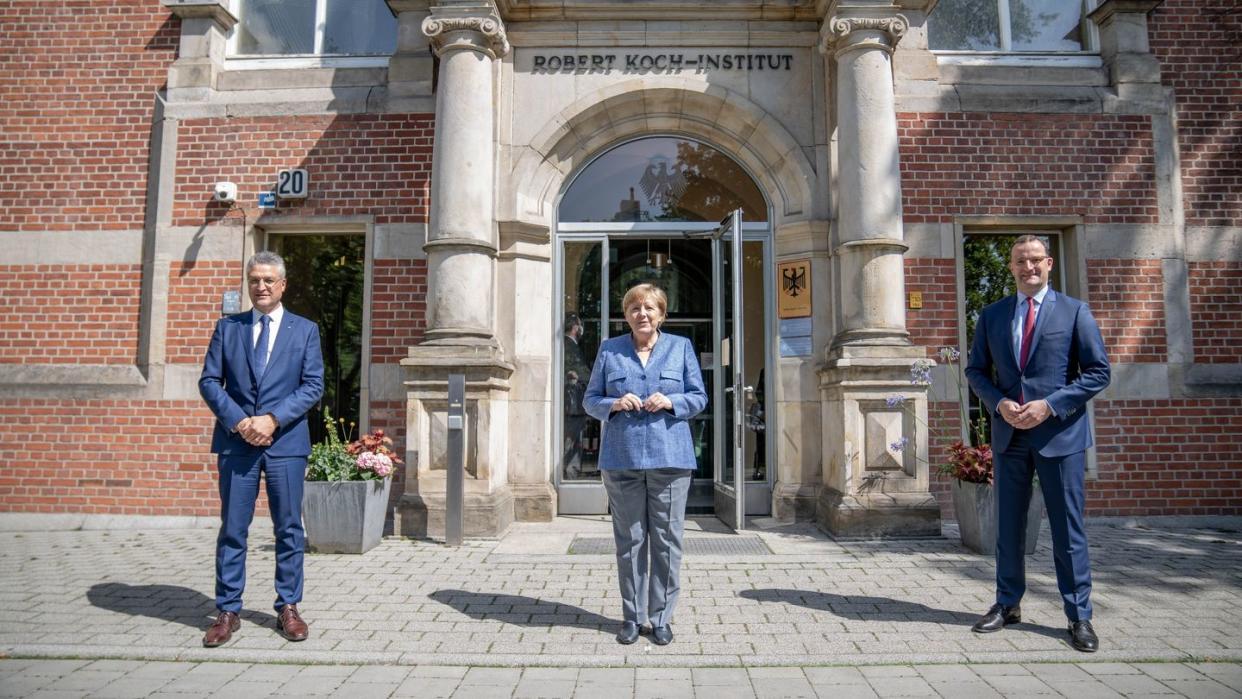 RKI-Präsident Lothar Wieler, Bundeskanzlerin Angela Merkel und Bundesgesundheitsminister Jens Spahn vor dem Eingang zum Robert Koch-Institut.