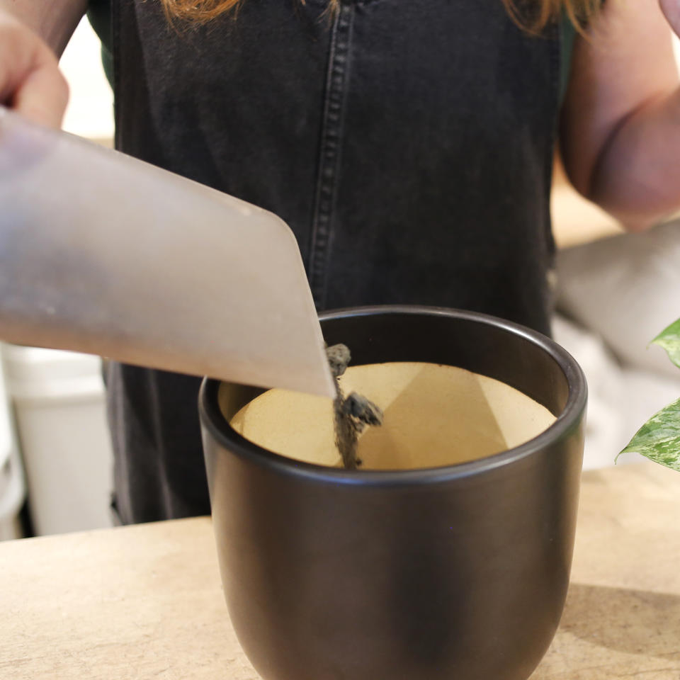 Brittney pouring lava rocks into a planter