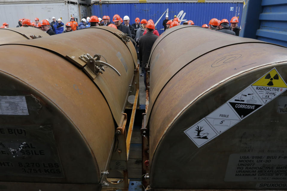 FILE - Representatives of participating companies gather near containers with uranium, before they are loaded on a vessel at a port in St. Petersburg, Russia, Thursday, Nov. 14, 2013. A 20-year program to convert highly enriched uranium from dismantled Russian nuclear weapons into fuel for U.S. power plants has ended, with the final shipment loaded onto a vessel in St. Petersburg's port on Thursday. The U.S. Energy Department described the program, commonly known as Megatons to Megawatts, as one of the most successful nuclear nonproliferation partnerships ever undertaken. (AP Photo/Dmitry Lovetsky, File)