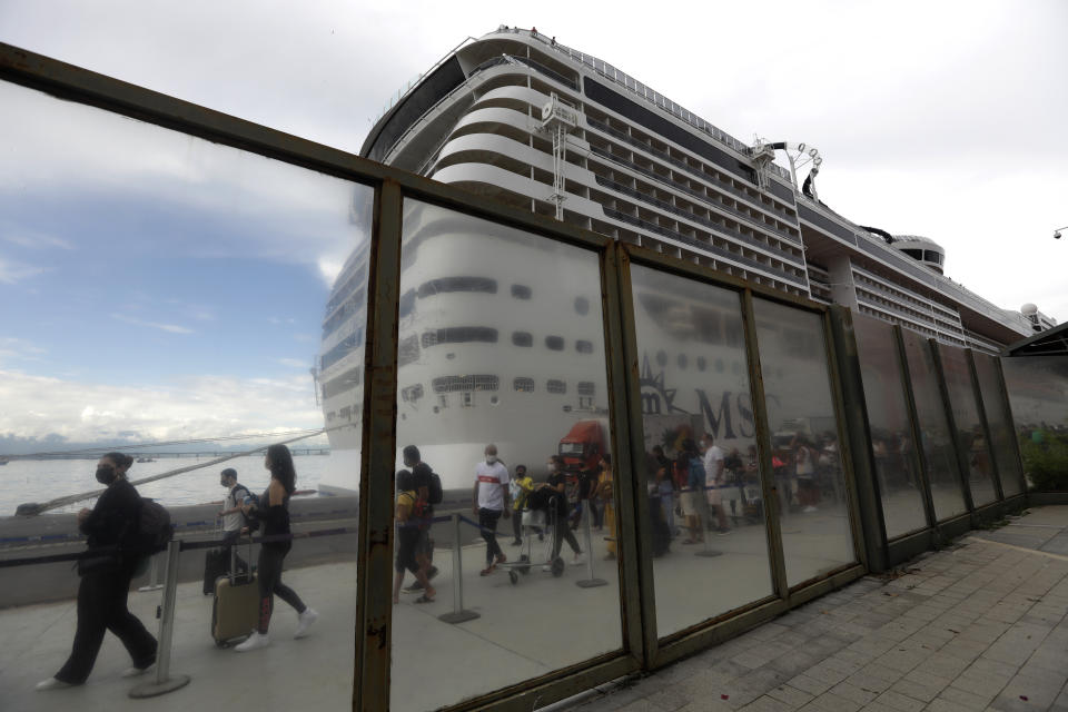 Passengers disembark from the cruise ship 'MSC Preziosa'', in the Port Area of Rio de Janeiro, Brazil, Sunday, Jan. 2, 2022, after Brazil's Sanitary Agency has confirmed more cases of COVID-19 on board. Rio's Health Secretariat said that those living in the city or nearby regions will be quarantined in their homes. Those who live outside the state will be isolated in hotels. (AP Photo/Bruna Prado)