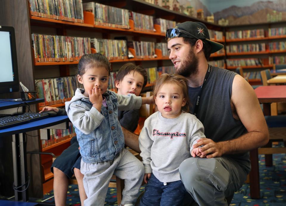 Jacob Madala, right, spends time with his children at the Palm Springs Public Library in Palm Springs, Calif., Dec. 13, 2023.