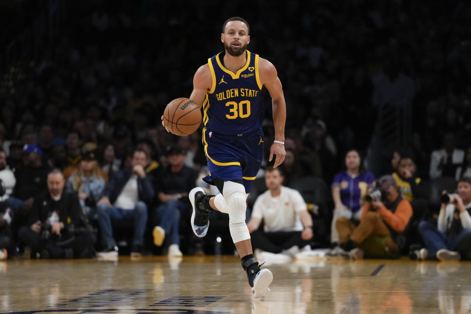 Golden State Warriors guard Stephen Curry controls the ball during the first half of an NBA basketball game against the Los Angeles Lakers in Los Angeles, Saturday, March 16, 2024. (AP Photo/Ashley Landis)
