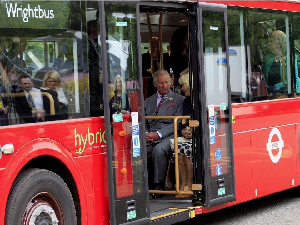Prince Charles and Camilla sit on a bus