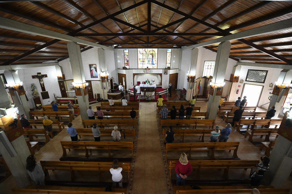 El sacerdote Honegger Molina oficia misa respetando las medidas de distanciamiento social y en una transmisión por redes sociales, en la parroquia Anunciación del Señor, en Caracas, Venezuela, el domingo 4 de octubre de 2020, en medio de la pandemia del coronavirus. (AP Foto/Matias Delacroix)