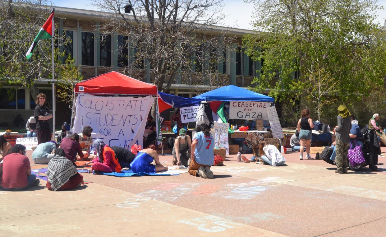 Pro-Palestinian protesters make signs while seated next to canopies erected for daily demonstrations by Students for Justice in Palestine on Thursday at Colorado State University in Fort Collins.