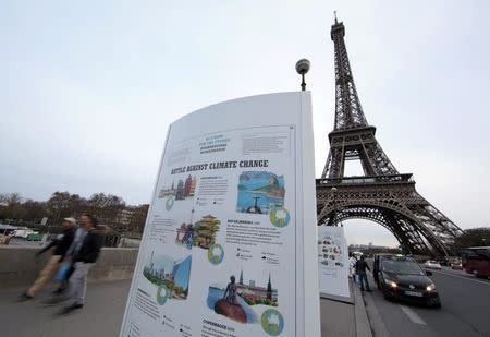 An information board about climate change is seen on a bridge near the Eiffel Tower ahead of the World Climate Conference 2015 (COP21), in Paris, France, November 28, 2015. REUTERS/Eric Gaillard