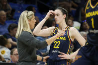 CORRECTS FROM CAITLYN TO CAITLIN - Indiana Fever head coach Christine Sides, left, talks to Fever guard Caitlin Clark (22) as they play the Dallas Wings during the first half of an WNBA basketball game in Arlington, Texas, Friday, May 3, 2024. (AP Photo/Michael Ainsworth)