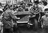 FILE - A jeep of the Algerian Liberation Front (FLN) is surrounded by an enthusiastic crowd in Algiers, Algeria, in July 1962. Algeria is celebrating 60 years of independence from France on Tuesday July 5, 2022 with nationwide ceremonies, a pardon of 14,000 prisoners and its first military parade in years. Tuesday's events mark 60 years since the official declaration of independence on July 5, 1962, after a brutal seven-year war which ended 132 years of colonial rule. The war, which killed at least 1.5 million people, remains a point of tension in relations between Algeria and France. (AP Photo, File)