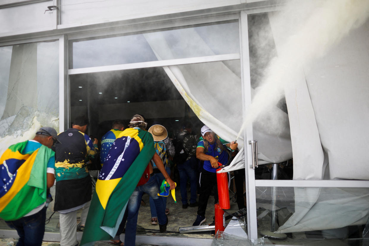 Supporters of Brazil's former President Jair Bolsonaro break into a building.