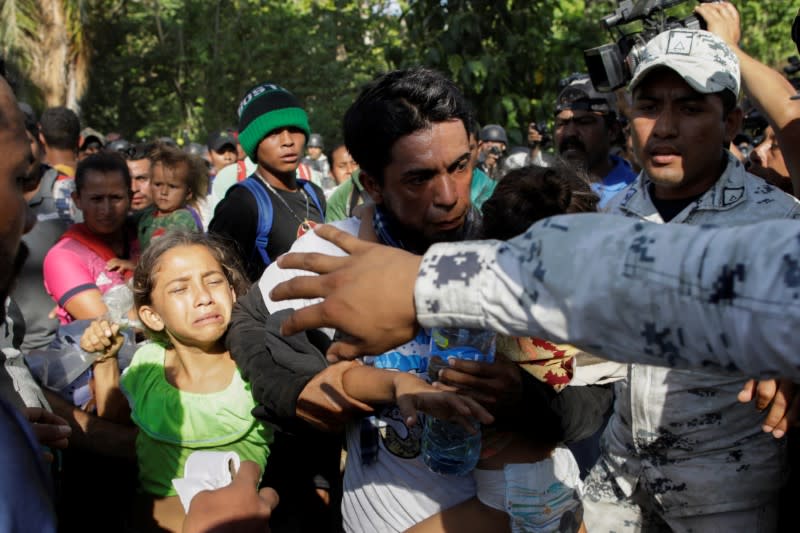 Migrants, mainly from Central America and marching in a caravan, scuffle with security forces, near Frontera Hidalgo, Chiapas