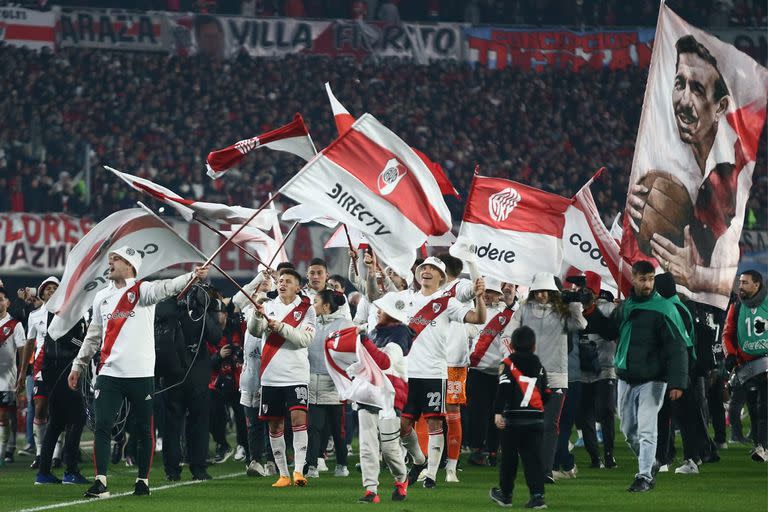 Los jugadores de River celebran durante la vuelta olímpica, mientras atrás los custodia la historia, con la imagen de Ángel Labruna