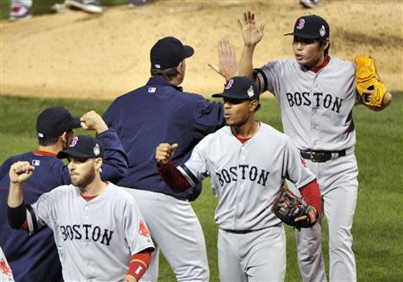 Oct 28, 2013; St. Louis, MO, USA; Boston Red Sox relief pitcher Koji Uehara (right, back) celebrates with Boston Red Sox manager John Farrell (left) after defeating the St. Louis Cardinals in game five of the MLB baseball World Series at Busch Stadium. Red Sox won 3-1. REUTERS