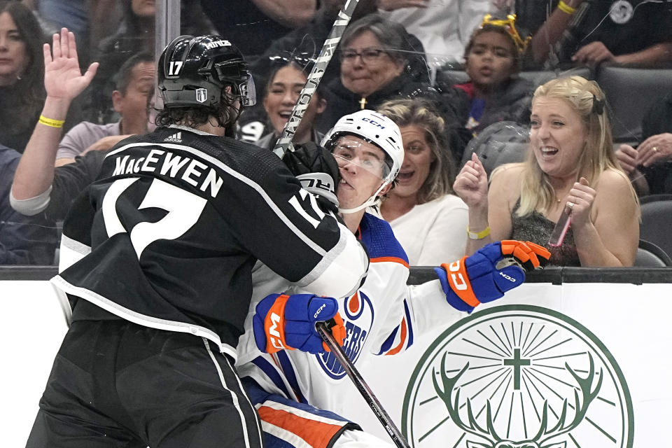 Los Angeles Kings center Zack MacEwen, left puts Edmonton Oilers center Ryan McLeod into the boards during the second period in Game 3 of an NHL hockey Stanley Cup first-round playoff series Friday, April 21, 2023, in Los Angeles. (AP Photo/Mark J. Terrill)