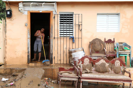 A woman sweeps mud out of a house flooded by an overflow of the Soco River in the aftermath of Hurricane Maria in El Seibo, Dominican Republic, September 22, 2017. REUTERS/Ricardo Rojas