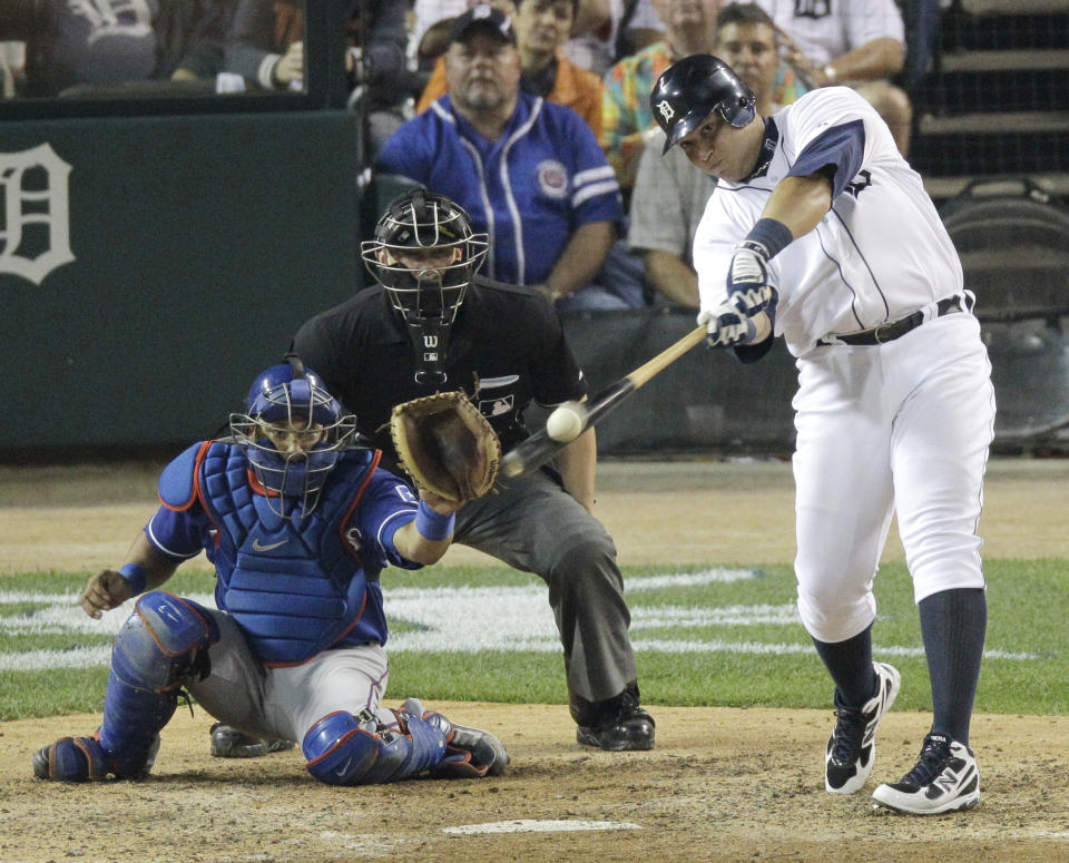 Detroit Tigers' Miguel Cabrera connects on a solo home run in front of Texas Rangers catcher Yorvit Torrealba and home plate umpire Jim Wolf during the seventh inning of Game 3 of baseball's American League championship series against the Texas Rangers, Tuesday, Oct. 11, 2011, in Detroit. (AP Photo/Mark Duncan)