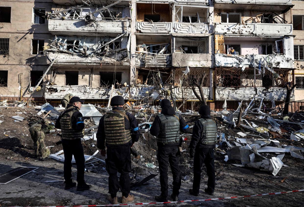 Ukraine militaries stand by the rubble of a destroyed apartment building in Kyiv on March 15, 2022, after strikes on residential areas killed at least two people, Ukraine emergency services said as Russian troops intensified their attacks on the Ukrainian capital. - A series of powerful explosions rocked residential districts of Kyiv early today killing two people, just hours before talks between Ukraine and Russia were set to resume. (Photo by FADEL SENNA / AFP) (Photo by FADEL SENNA/AFP via Getty Images)