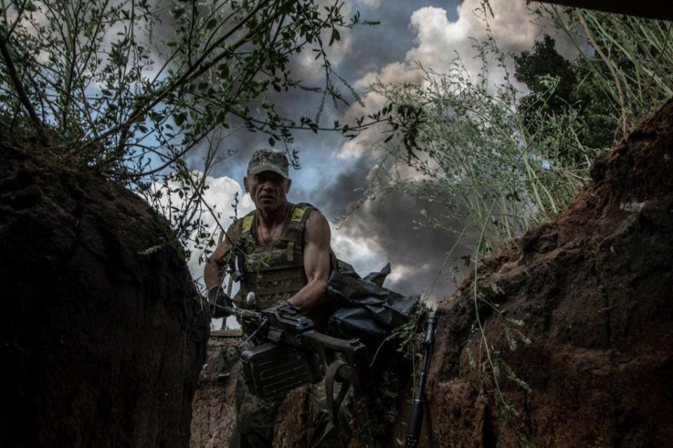 A paratrooper from the 81st Airmobile Battalion takes shelter in a trench from a BM-21 Grad multiple rocket launcher attack which has destroyed a neighboring house on July 5,2022 in Seversk, Ukraine.