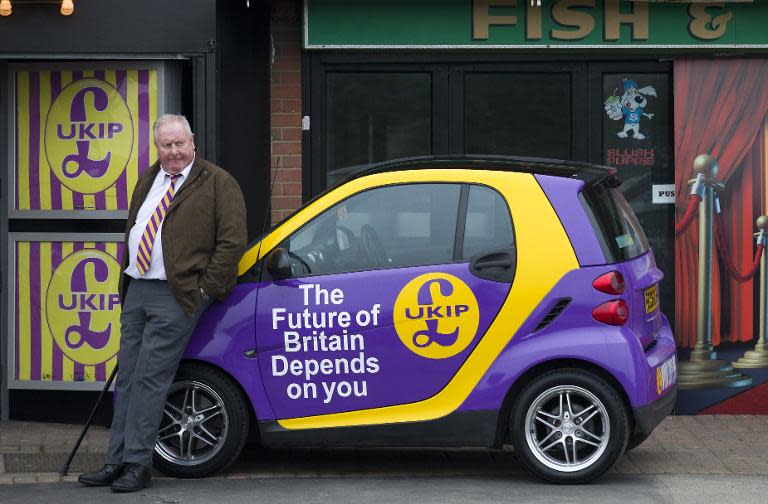 A UKIP supporter leans on a campaign car as Britain's UKIP party leader Nigel Farage delivers his first major speech of the 2015 Generel Election campaign in Canvey Island, east of London, on February 12, 2015
