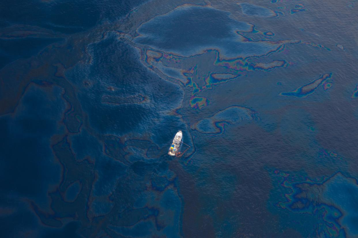 A ship floats amongst a sea of spilled oil in the Gulf of Mexico after the BP Deepwater Horizon oil spill disaster.