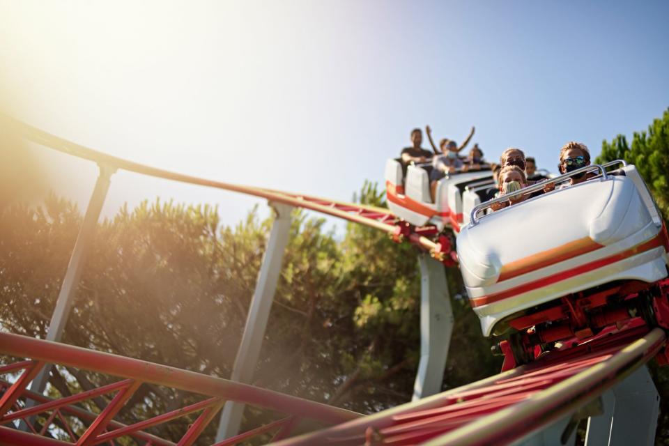 An image of people on a rollercoaster with masks on.